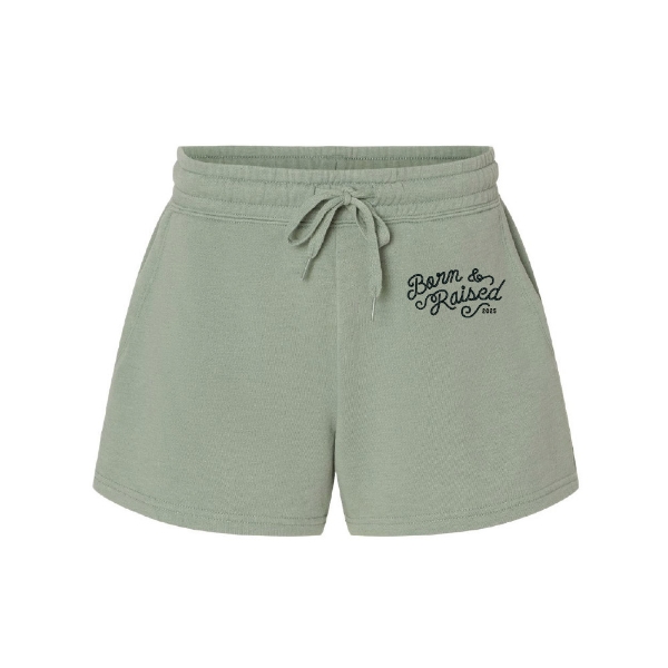Front view of sage green Born & Raised Shorts with 2025 script logo and drawstring waistband